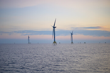 Electricity production by offshore wind turbine farm in the sea. Clean wind energy production in...