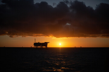 Offshore Wind Farm electrical distribution station in the sea at sunrise.