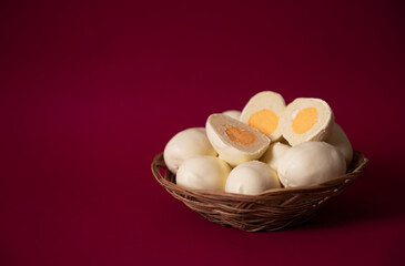 New trends for Easter: cupcake in the form of an egg, filling in the form of egg yolk from lemon cream, and covered with white chocolate. Easter eggs in a basket on a background of Viva Magenta color