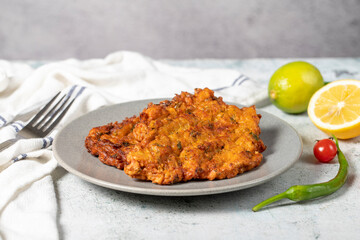 Mucver on the gray background. Frying dinner made of pumpkin