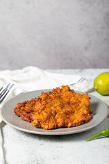 Mucver on the gray background. Frying dinner made of pumpkin