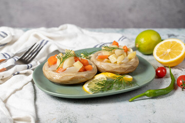 Artichoke with vegetables on gray floor. Artichoke dinner made with olive oil, potatoes, carrots and onions. Healthy food