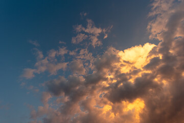 Fototapeta premium Perfect background Bright golden orange clouds illuminated by sunlight. Summer evening bright sky