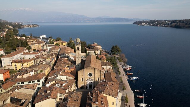 Europe, Italy, Brescia , Garda lake , Salo' drone aerial view of  village with church and lake with blue water - Italian  Republic from 1943 to 1945 during the reign of Benito Mussolini fascist 