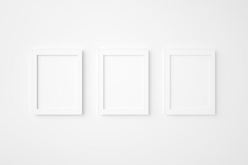 Three blank or empty rectangle picture frames hanging on white wall. Mockup background image. 3D rendering.