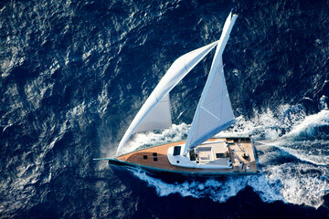 Nacira 67 designed by Axel de Beaufort. The result is a wide planning hull shape equipped with a canting keel, twin rudder direction system and a 30 m high rotating mast.