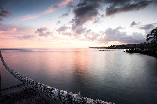 Dusk photograph off a dock on Samoa, pink light in the sunset.