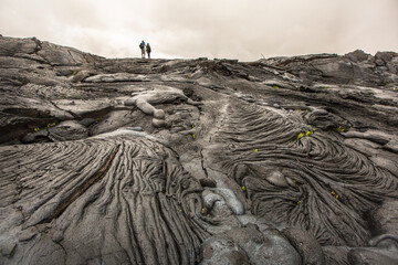 Two People Walking On Lava Fields At The Big Island Of Hawaii