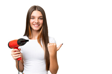 Teenager Caucasian girl holding a hairdryer over isolated background pointing to the side to present a product