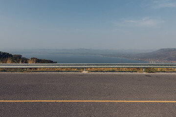 The guard rail, barrier on wayside with cloudy and hill. the straight line from highway fence....