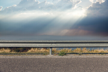 The guard rail, barrier on wayside with cloudy and hill. the straight line from highway fence....