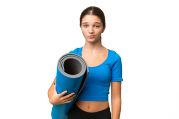 Teenager caucasian girl going to yoga classes while holding a mat over isolated background with sad expression