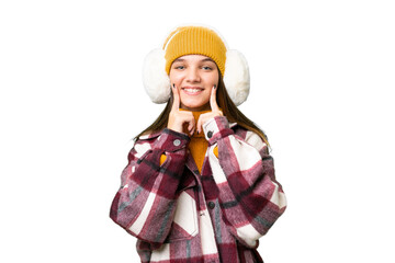 Teenager caucasian girl wearing winter muffs over isolated background smiling with a happy and...