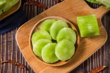 Fresh peeled asparagus lettuce on wooden table.