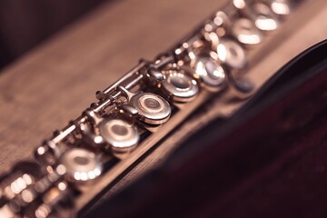 Obraz premium A close up portrait of a the valves of an assembled silver metal flute. The musical instrument is ready to be played by a musician or flutist.