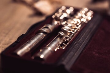 A portrait of a valve of a disassembled metal silver flute in a case. The musical instrument needs to be put together again in order for a flutist or musician to play a piece. © Joeri
