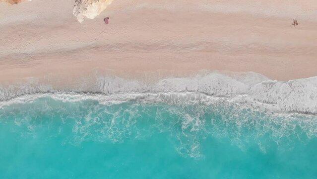 Slow motion: aerial view of beautiful empty beach in Greece, no people. Dramatic coastline scenic bay rocky cliffs in the Ionian island, Port Katsiki, Lefkada. Blue turquoise waving sea.