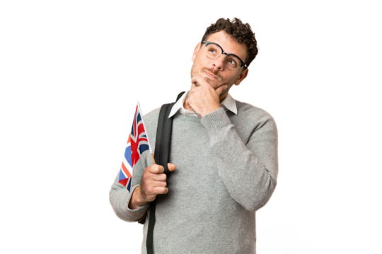 Brazilian man holding an United Kingdom flag over isolated chroma key background having doubts