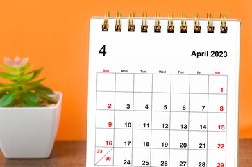Close up the April 2023 Monthly desk calendar on wooden table.