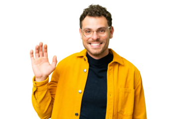 Brazilian man over isolated chroma key background saluting with hand with happy expression