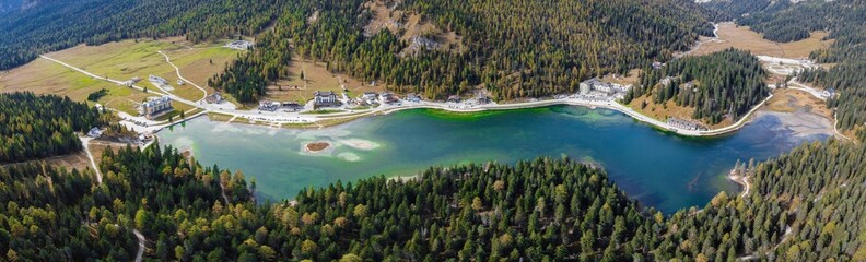 Aerial drone. Lake Misurina in the Italian Dolomites near Cortina D'Ampezzo. Sunny summer day with blue sky and clouds