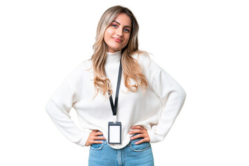 Young Uruguayan woman with ID card over isolated background posing with arms at hip and smiling