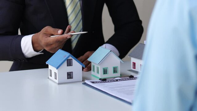 Real estate agent is explaining the details of a home to a client. The concept of signing a house purchase agreement in a real estate project.