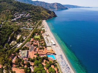 Aerial drone. Capo Calava bay and beach, with several holiday parks, resort and villages, near Gioiosa Marea, Sicily, Italy.