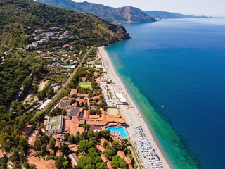 Aerial drone. Capo Calava bay and beach, with several holiday parks, resort and villages, near...