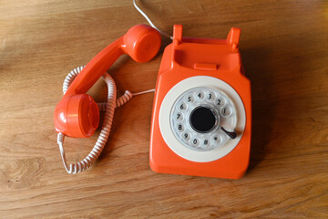 old red telephone on wooden table