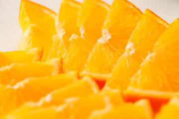 Fototapeta na wymiar Sliced oranges lie in row on plate, selective focus