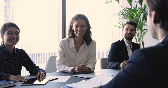 Group of successful smiling businesspeople, office employees attend formal meeting, share thoughts, ideas, solve business, engaged in negotiations in modern board room, discuss deal looking positive