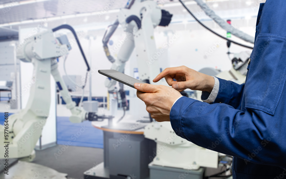 Leinwandbilder engineer uses a digital tablet to control robots in a smart factory. smart industry 4.0 concept
