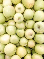 Green apples in large quantities. Fresh apples as background. Apples on the shelves of the supermarket and market. Fresh fruit. Vitamins.