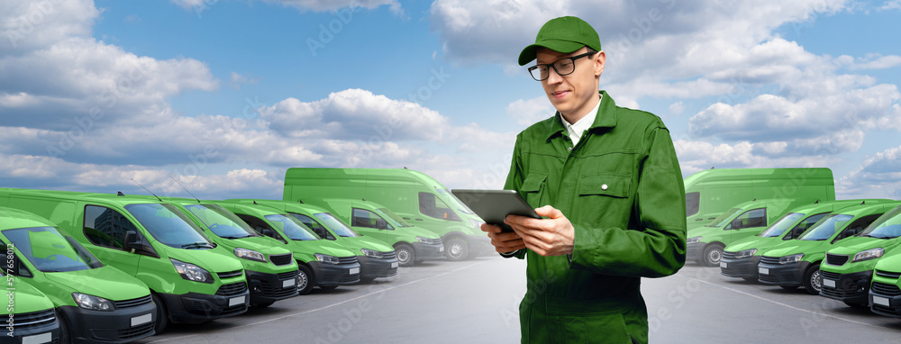 Poster Manager with a digital tablet on the background of vans. Fleet management	