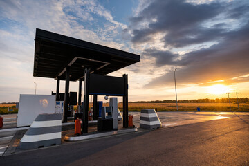 Modern self service gas station against the backdrop of a dramatic sunset sky	