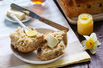 Cross buns served with butter, honey and tea. Easter breakfast.