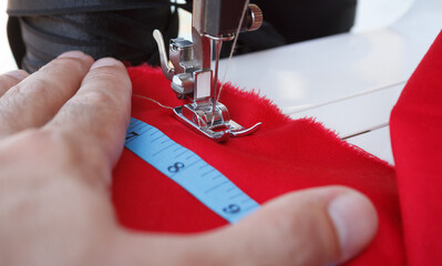 Tailor stitching cloth with professional electric sewing machine. Close up focus on needle on textile