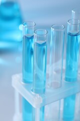 Test tubes with light blue liquid in laboratory, closeup