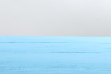 Empty light blue wooden surface on white background. Space for text