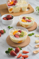 Fresh Fruit Salad made of strawberries, grapes, longan and apple and grated cheese
