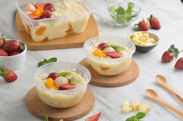 Fresh Fruit Salad made of strawberries, grapes, longan and apple and grated cheese
