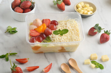 Fresh Fruit Salad made of strawberries, grapes, longan and apple and grated cheese
