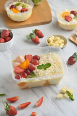 Fresh Fruit Salad made of strawberries, grapes, longan and apple and grated cheese
