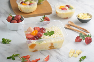 Fresh Fruit Salad made of strawberries, grapes, longan and apple and grated cheese
