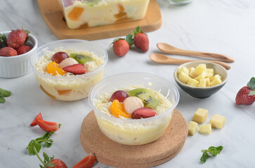 Fresh Fruit Salad made of strawberries, grapes, longan and apple and grated cheese
