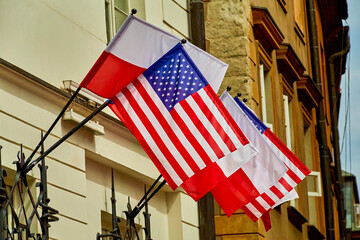 Flags of the USA and Poland hang outside on the house