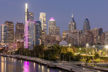 Obraz premium Philadelphia Downtown skyline at Night with the Schuylkill river. Beautiful Sunset Light. Schuylkill River Trail in Background. City skyline glows under the beautiful sunset light. Cityscape. PA, USA.