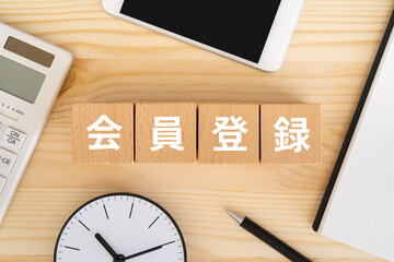 会員登録と書かれたブロック、電卓、スマホ、ノート
