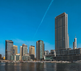 Fototapeta na wymiar Dubai Marina, harbour, cruise boat and canal promenade view at sunset, in Dubai, United Arab Emirates
